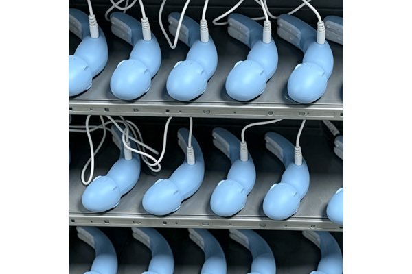 Silicone vibrators undergoing charging verification on a production rack