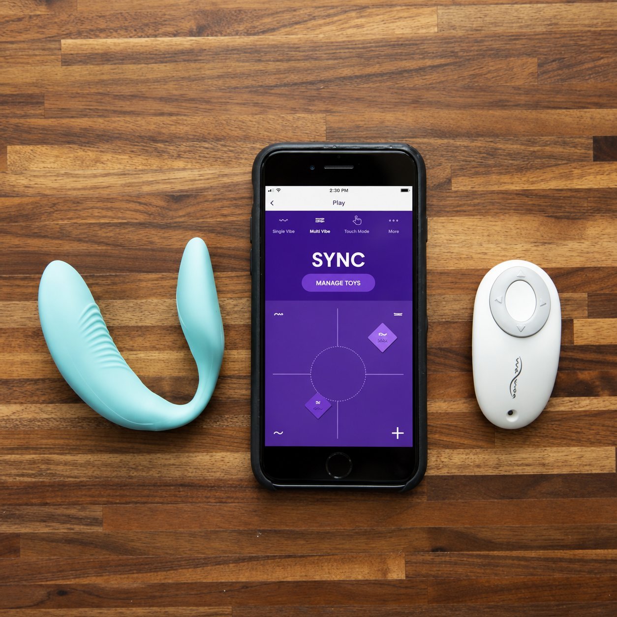 Teal dual-stimulation vibrator, white remote control, and iPhone showing a SYNC multi-toy control screen
