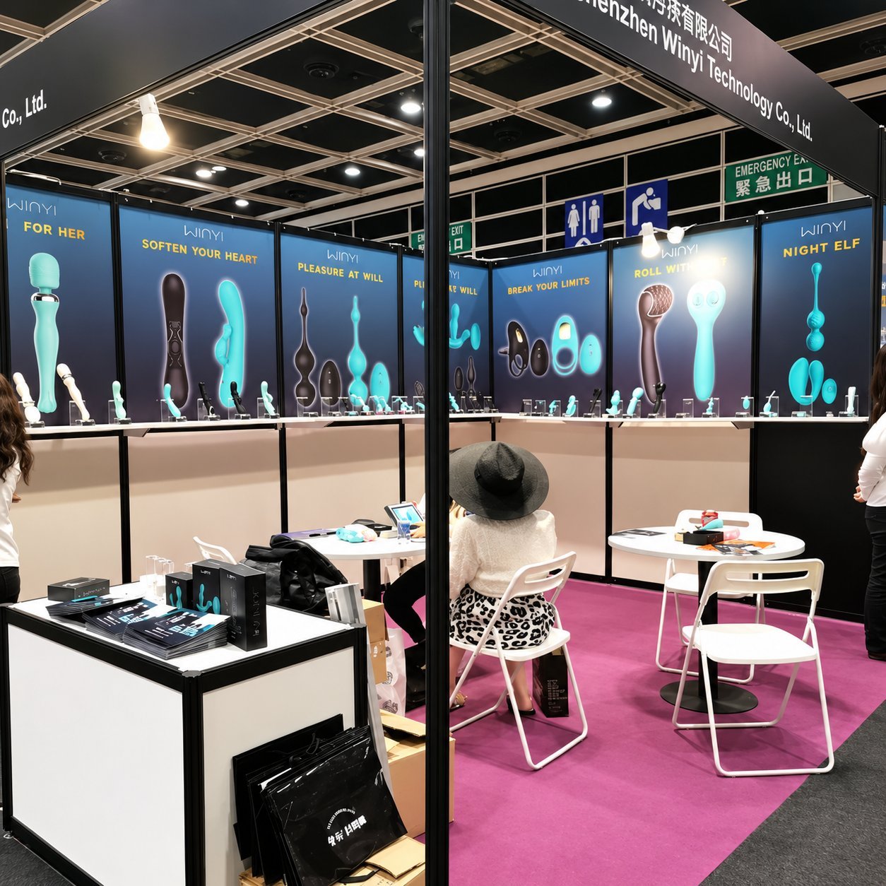 WINYI booth interior with pink carpet, blue panel product displays with categories including FOR HER, SOFTEN YOUR HEART, PLEASURE AT WILL, BREAK YOUR LIMITS, NIGHT ELF