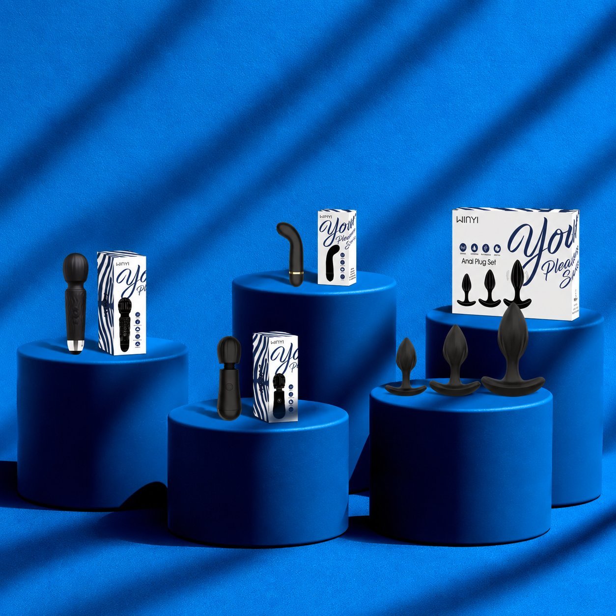 WINYI Yoli product packaging in blue and white zebra-print boxes with three black products displayed on blue cylindrical pedestals against a draped blue background